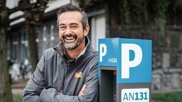 Bart, teamverantwoordelijke parkeerwachters naast een parkeerzuil