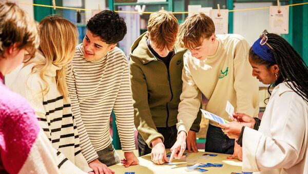 Diverse groep jongeren werken aan een project in het Letterenhuis