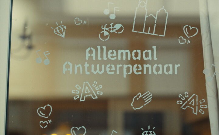 Tekst 'Allemaal Antwerpenaar' op een raam