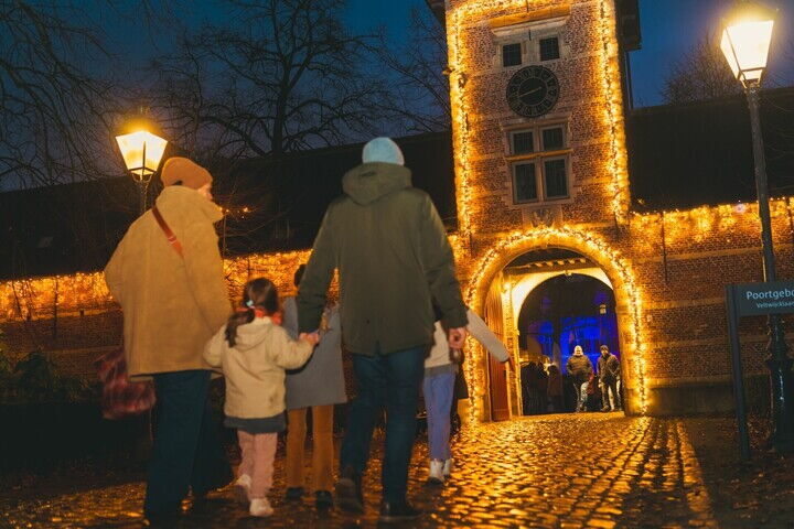 Een gezin loopt naar verlichte kraampjes